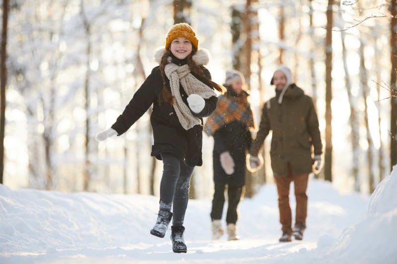 Familie beim Waldspaziergang im Schnee