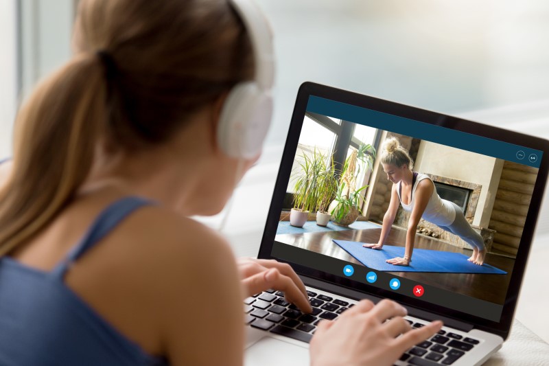 Frau schaut Rückenübungen-Video am Laptop